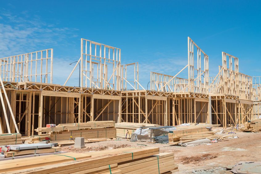 new residential construction home framing against a blue sky.